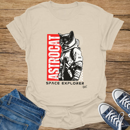 Astronaut cat graphic with text "ASTROCAT" and "SPACE EXPLORER" on a cream t-shirt.