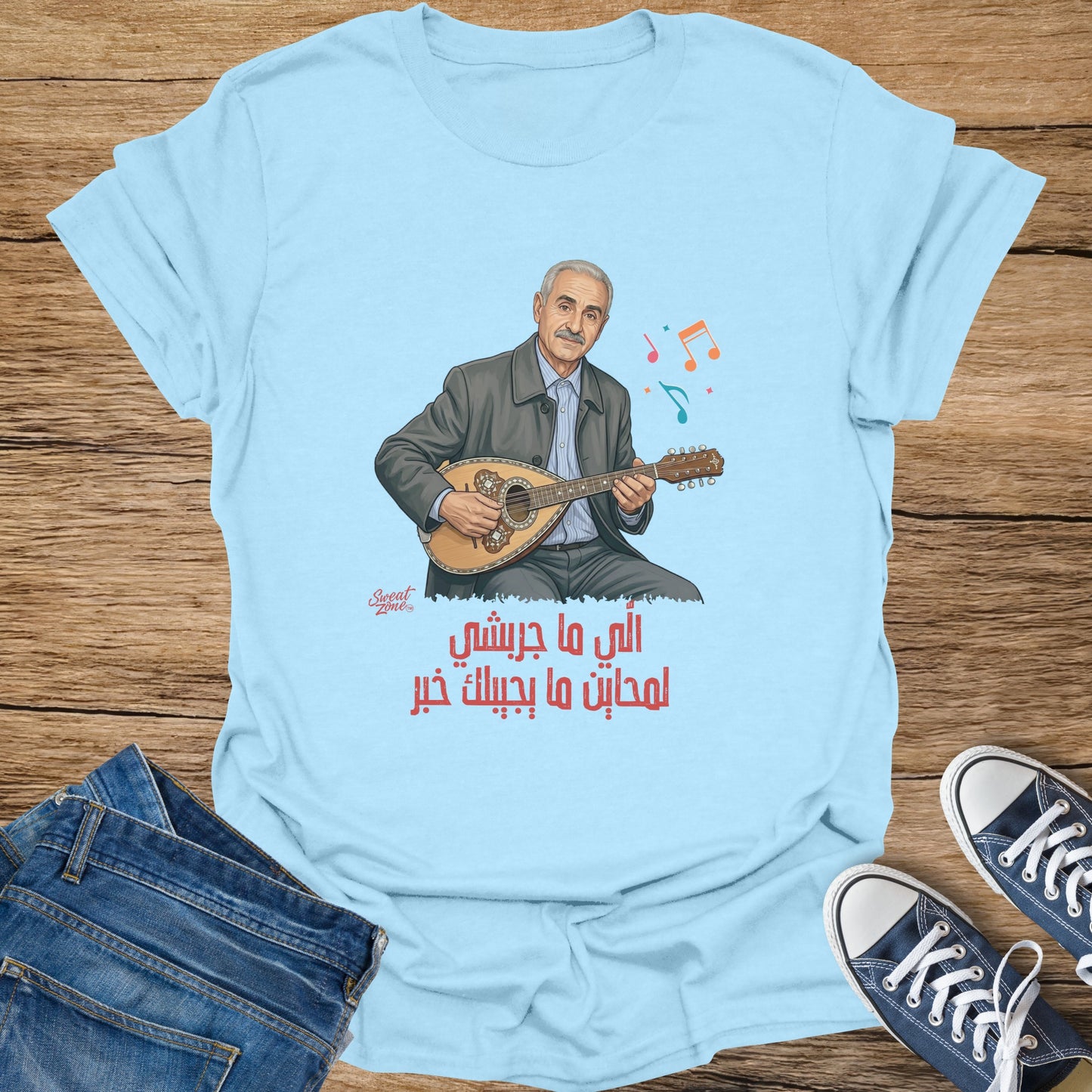 Blue t-shirt with illustration of man playing oud and Arabic text.