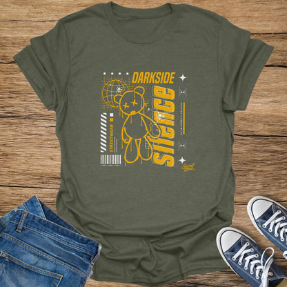 Olive t-shirt with yellow graphic of a teddy bear, globe, and text "DARK SIDE SILENCE".