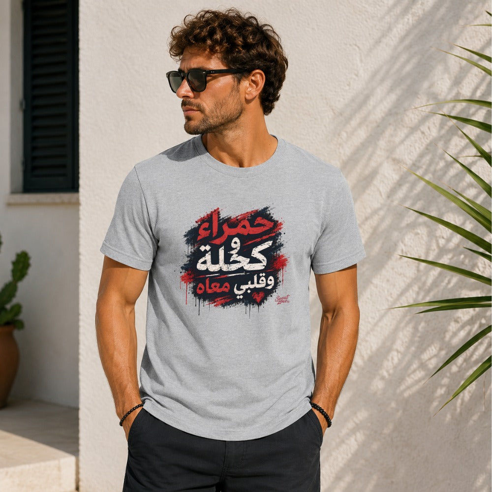 Man wearing grey t-shirt with red, blue, and black Arabic text graphic.