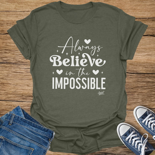 Olive green t-shirt with white text that reads "Always Believe in the Impossible."