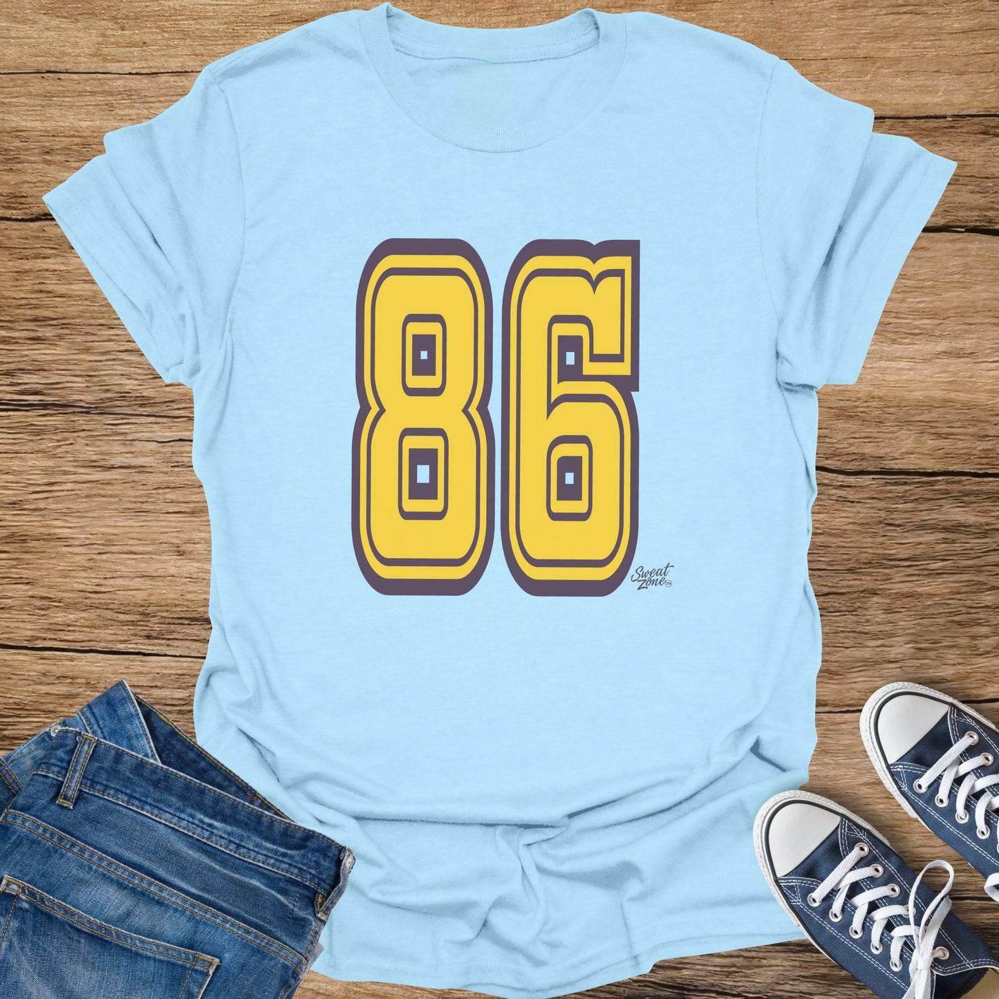 Light blue t-shirt with large yellow number 86 and a small sweat zone logo.