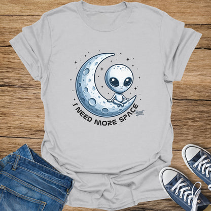 Gray t-shirt with alien on crescent moon graphic that says "I NEED MORE SPACE".