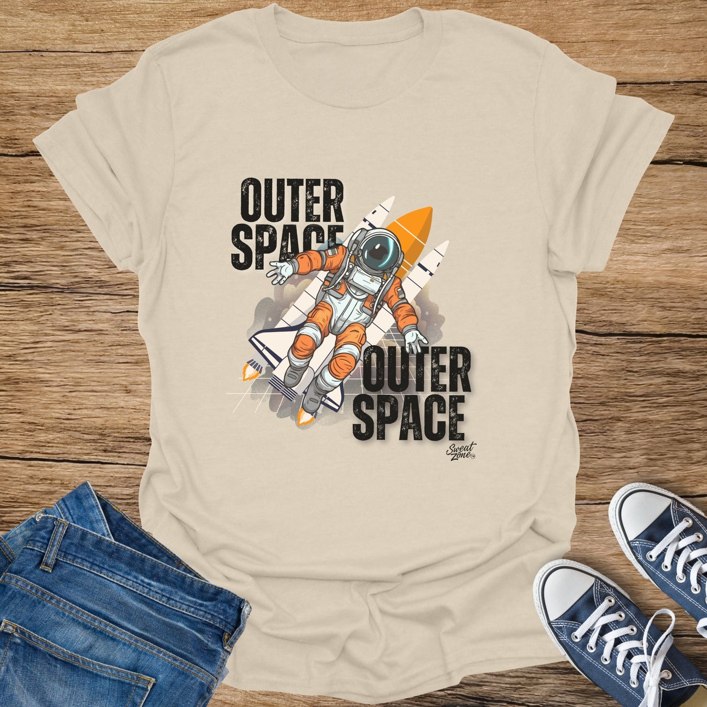 Cream t-shirt with "Outer Space" text and astronaut with rocket graphic.