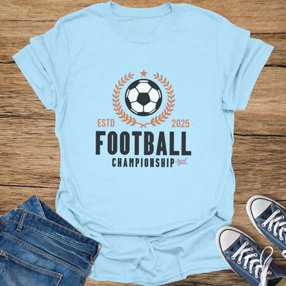 Light blue t-shirt with "Football Championship" graphic, ESTD 2025, and Sweat Zone logo.