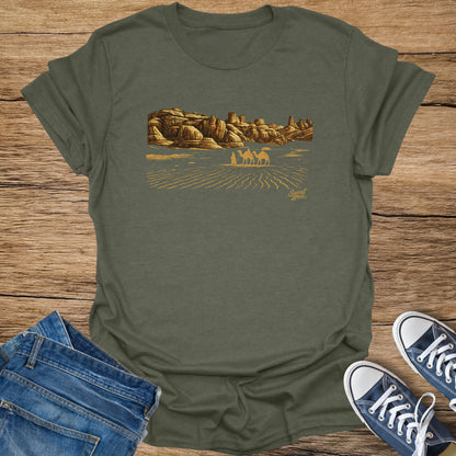 Olive green t-shirt with desert landscape and camels printed on it.