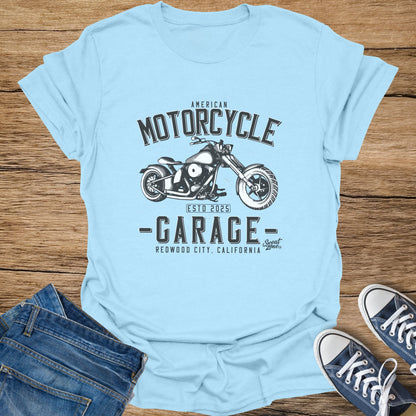 Light blue t-shirt with "American Motorcycle Garage" graphic and "Redwood City, California" text.