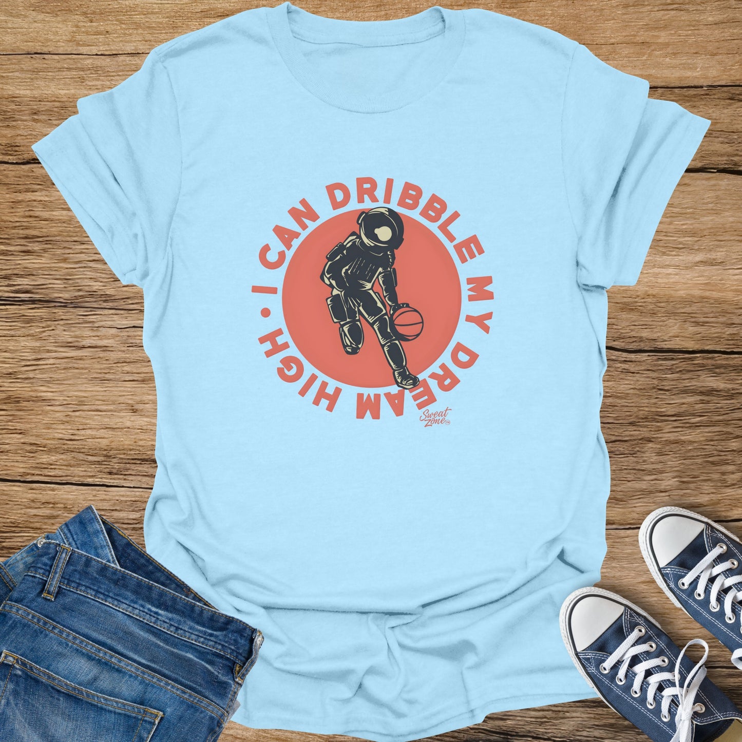 Light blue t-shirt with astronaut dribbling a basketball and text "I CAN DRIBBLE MY DREAM HIGH".