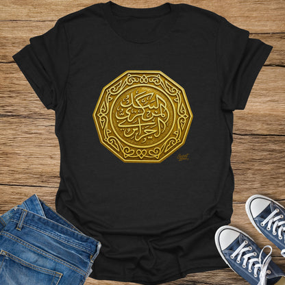 Black t-shirt with a gold octagonal emblem featuring Arabic calligraphy.