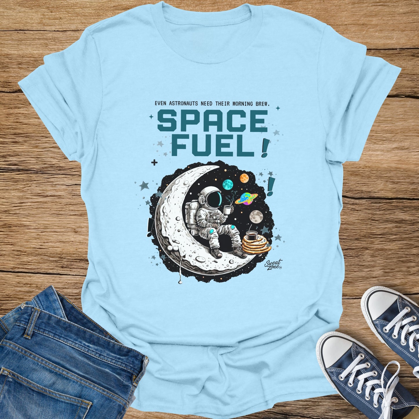 Light blue t-shirt with astronaut on moon drinking coffee and the text "SPACE FUEL!".