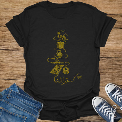Black t-shirt with gold embroidered desert caravan, sailboat, rug, earring, and Arabic script.