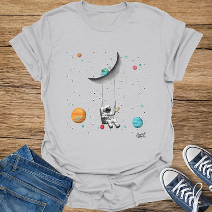Astronaut on a swing from the moon, with planets and stars, and a rocket.