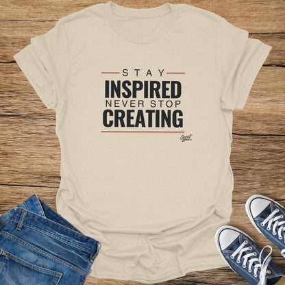 Cream t-shirt with text "Stay Inspired Never Stop Creating" and "Sweat Zone" logo.