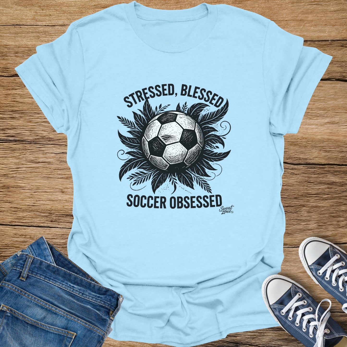 Light blue t-shirt with text "STRESSED, BLESSED SOCCER OBSESSED" and a soccer ball graphic.