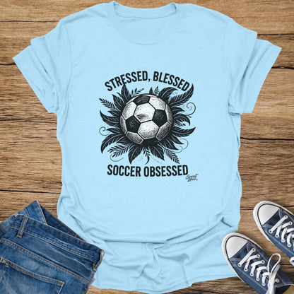 Light blue t-shirt with text "STRESSED, BLESSED SOCCER OBSESSED" and a soccer ball graphic.