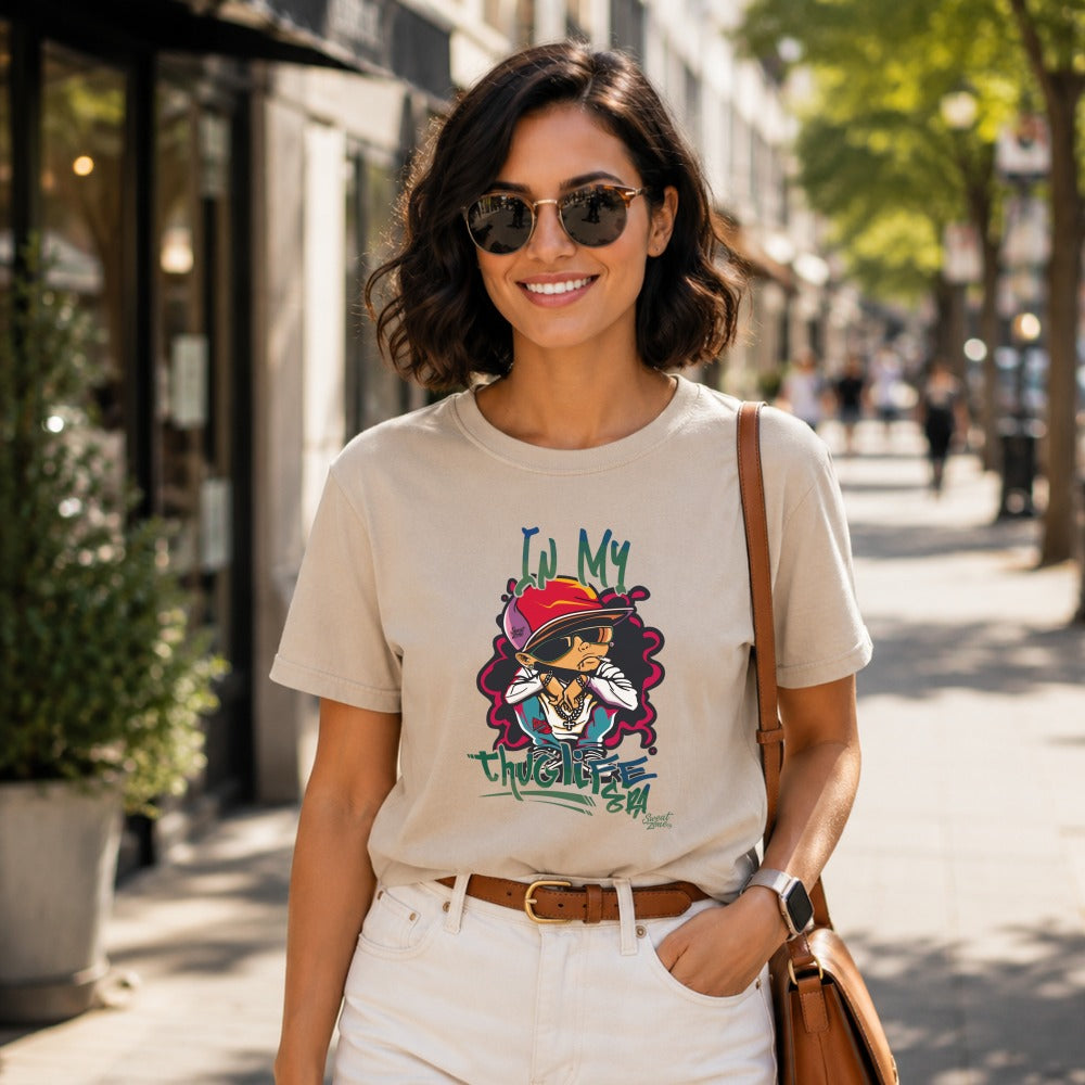 Tan t-shirt with "In My Thug Life Era" graphic on a woman outdoors.