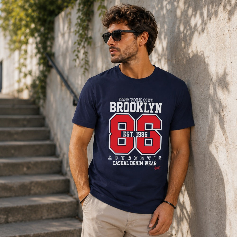 Navy t-shirt with "Brooklyn 86 Est. 1986" graphic on a man.