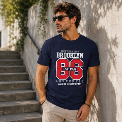 Navy t-shirt with "Brooklyn 86 Est. 1986" graphic on a man.