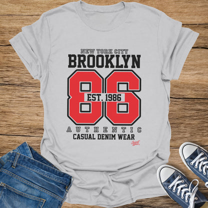 White t-shirt with "New York City Brooklyn 86 Est. 1986" graphic.
