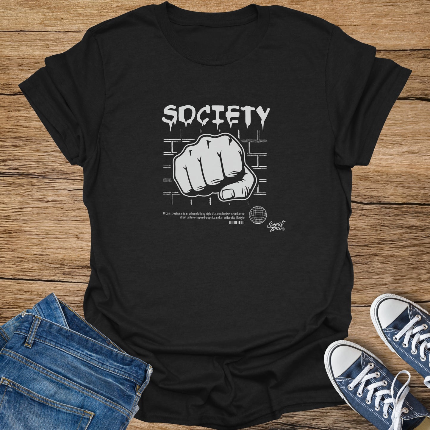 Black t-shirt with "SOCIETY" and a fist graphic, brick background.
