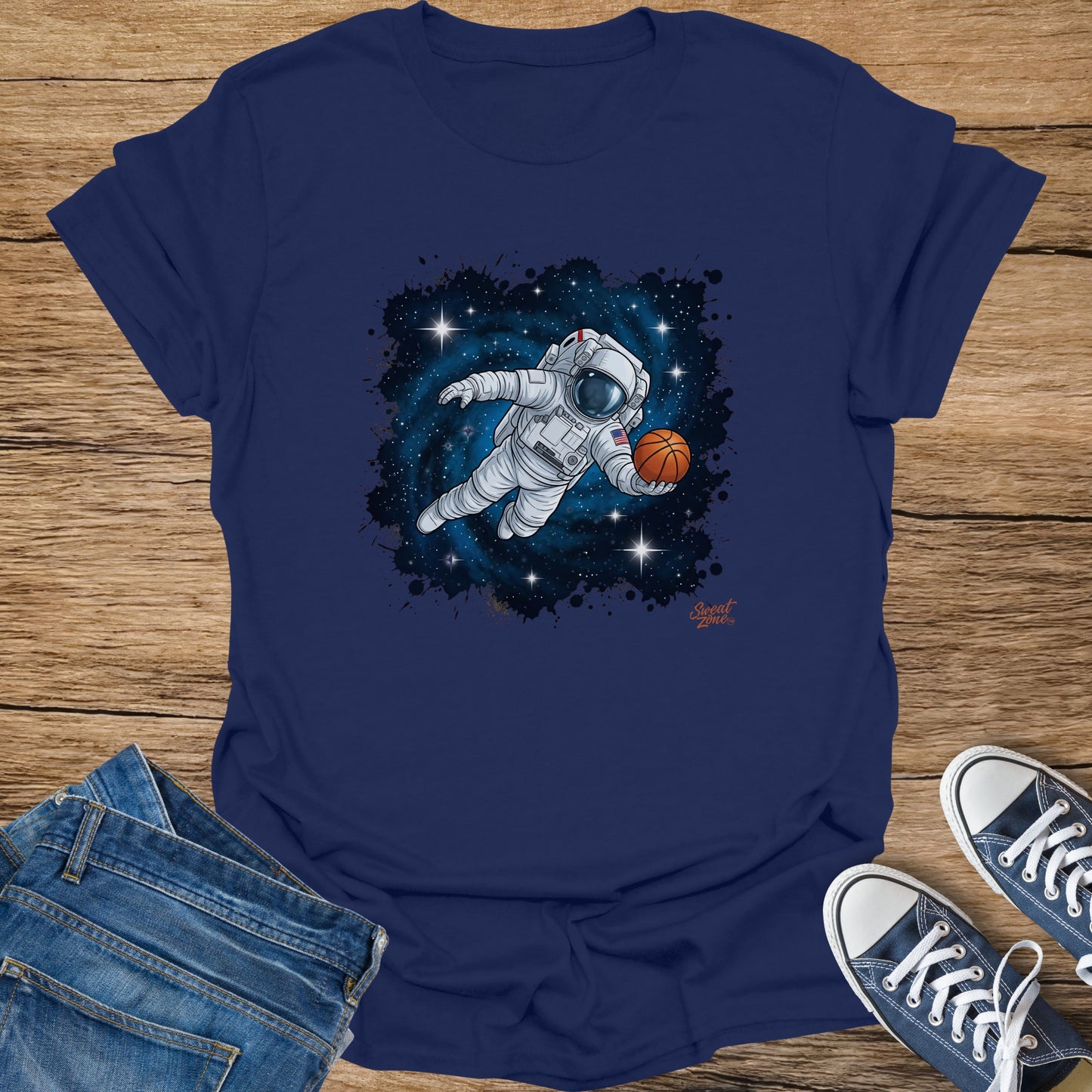 Astronaut playing basketball in space against a starry background on a navy t-shirt.