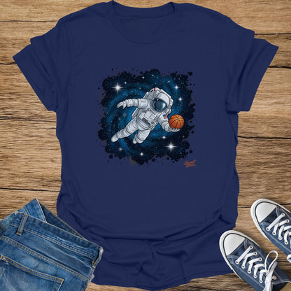 Astronaut playing basketball in space against a starry background on a navy t-shirt.