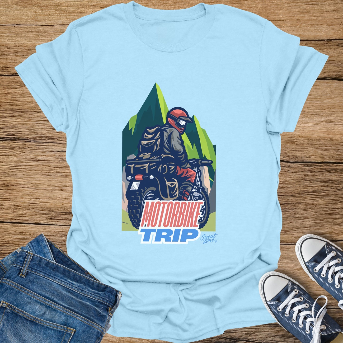 T-shirt design with rider on motorbike against mountains, text "MOTORBIKE TRIP".