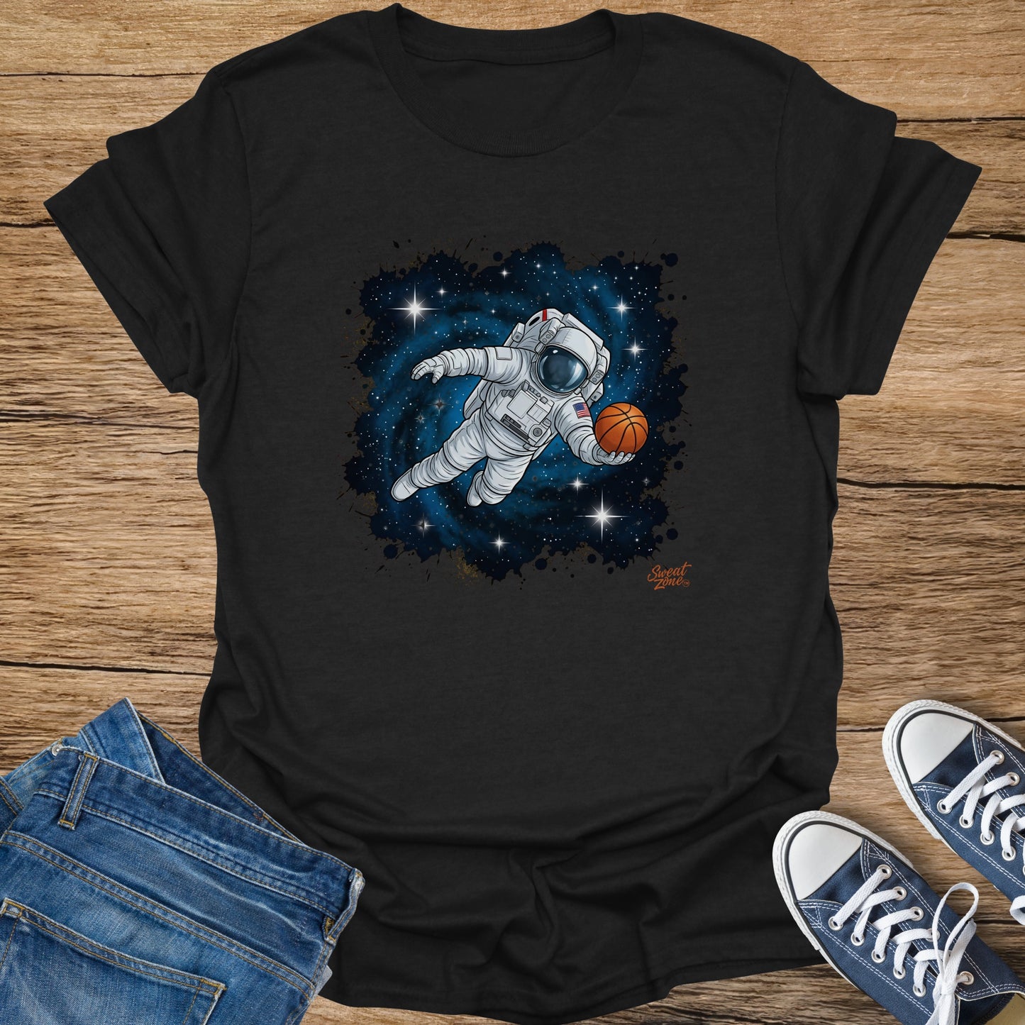 Astronaut playing basketball in space with stars and a nebula on a black t-shirt.