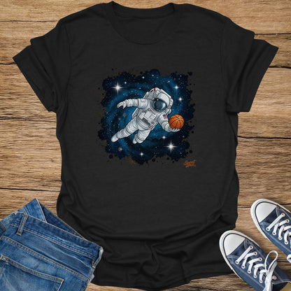 Astronaut playing basketball in space with stars and a nebula on a black t-shirt.
