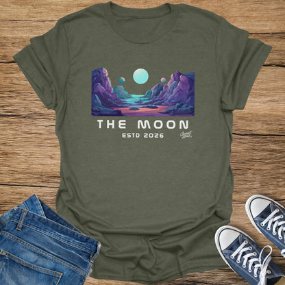 Green t-shirt with "THE MOON ESTD 2026" text and lunar landscape graphic.