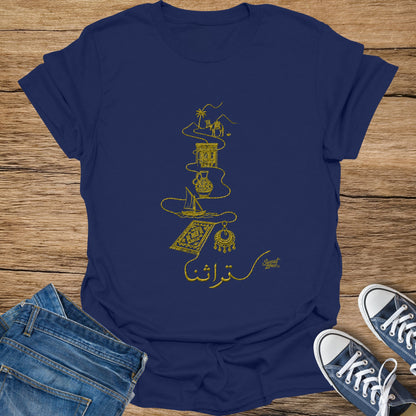 Navy t-shirt with gold embroidery of desert landscape, camel, pottery, and rug with Arabic text.