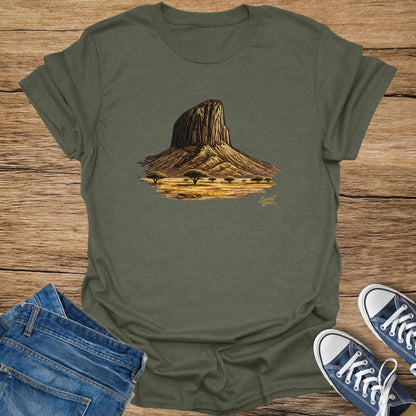 Olive green t-shirt with a drawing of a rocky mesa and scattered trees.