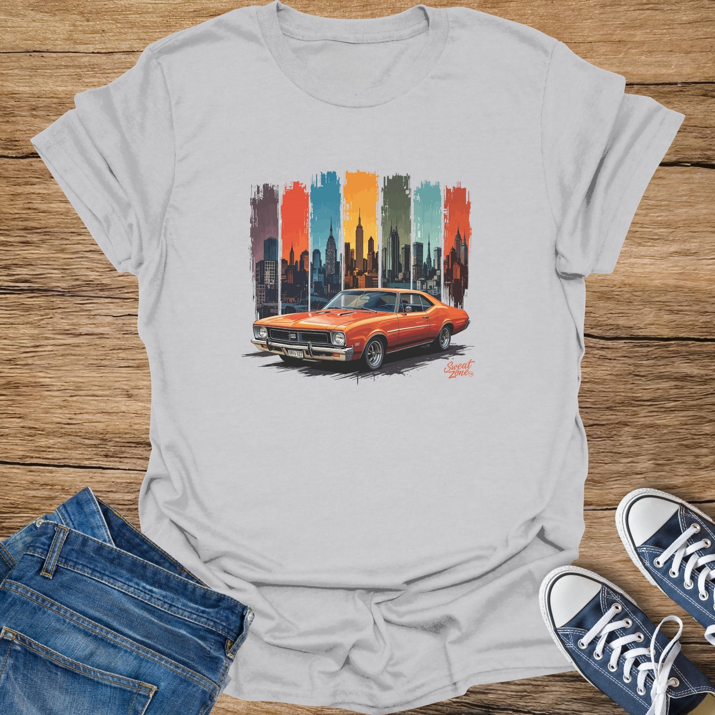 Vintage orange muscle car in front of a stylized city skyline and colored vertical stripes.