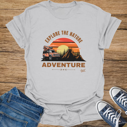 Light grey t-shirt with orange camper van, mountains, and sunset graphic reading "Explore the Nature Adventure."