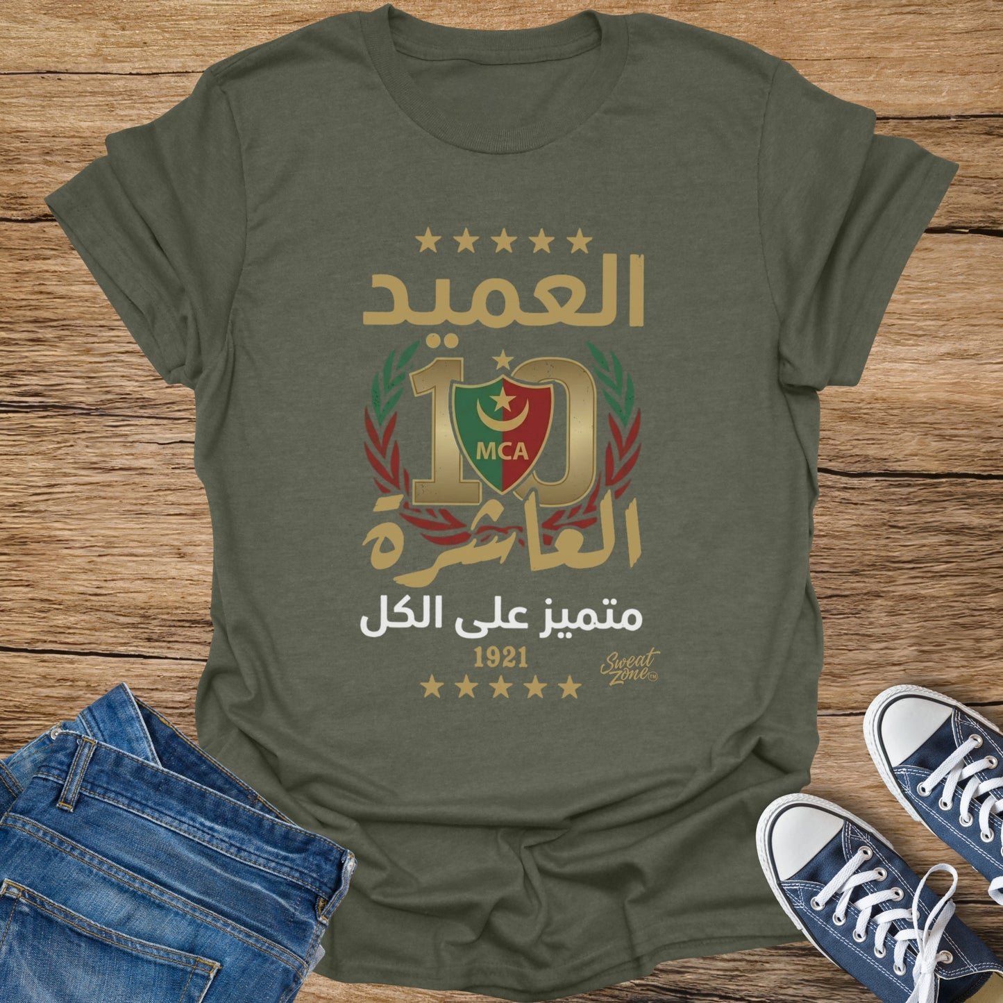 Green t-shirt with Arabic text, MCA logo, and year 1921.