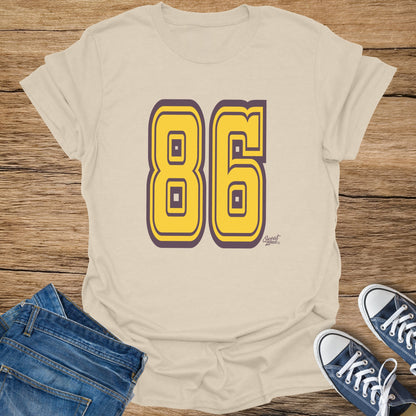 Tan t-shirt with oversized yellow 86 graphic and small "Sweat Zone" logo.